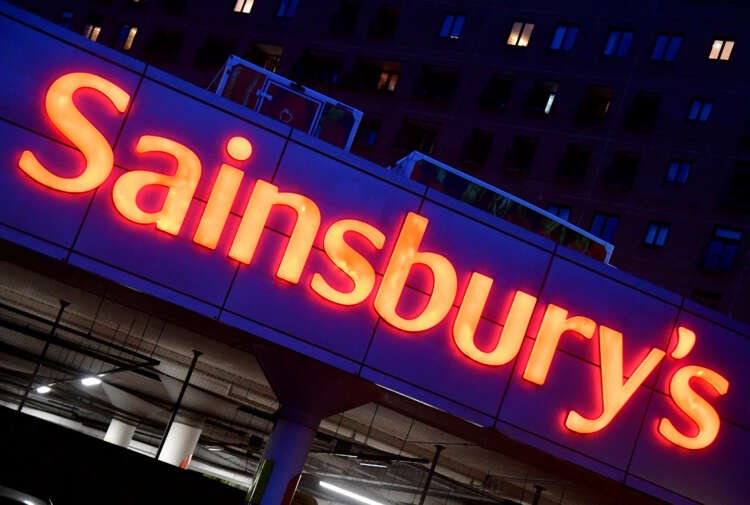 Illuminated Sainsbury's signage in London showcasing price cuts amid UK inflation concerns - Global Banking & Finance Review