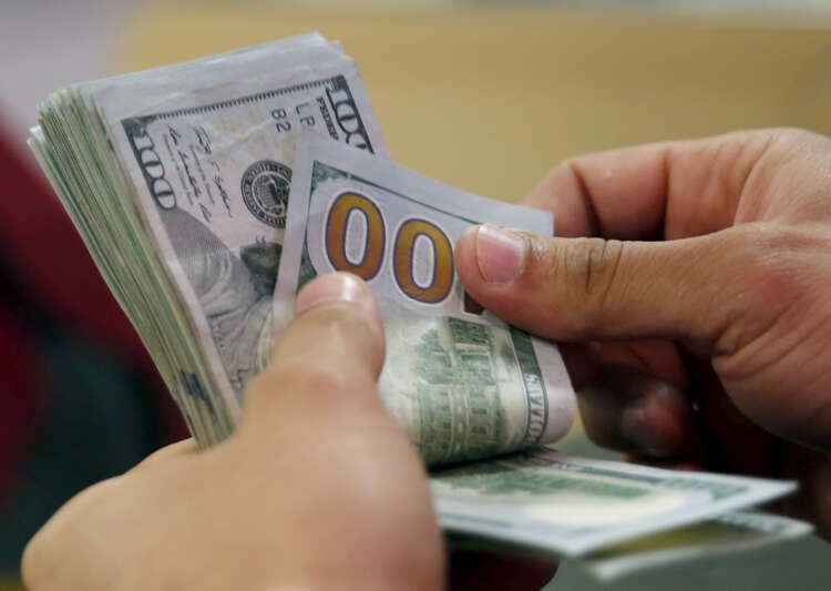 A customer counts his U.S. dollar money in a bank in Cairo