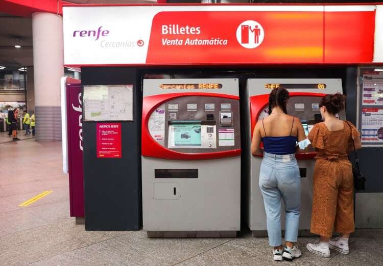 A young woman holds a free rail travel pass at Madrid's Atocha station - Global Banking & Finance Review