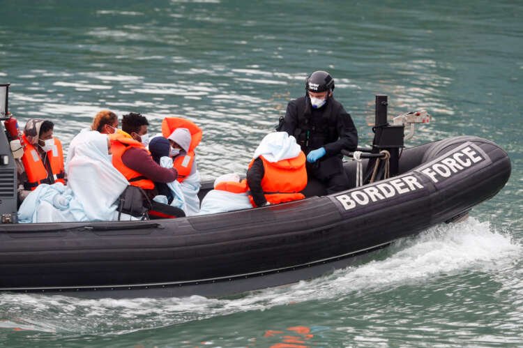 Border Patrol agents bring migrants into Dover harbour on a boat - Global Banking & Finance Review