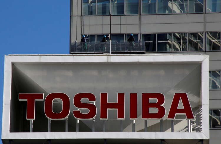 FILE PHOTO: Logo of Toshiba Corp is seen as Window cleaners work on the company’s headquarters in Tokyo