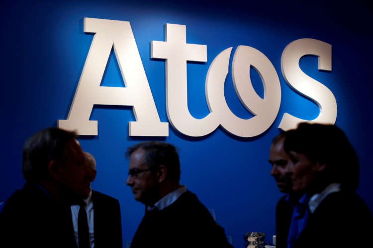 FILE PHOTO: FILE PHOTO: People walk in front of the Atos company’s logo during a presentation of the new Bull sequana supercomputer in Paris