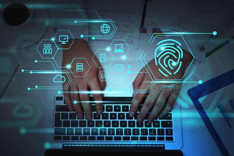 Businessman using keyboard with fingerprint and data symbols, representing digital identity in banking - Global Banking & Finance Review