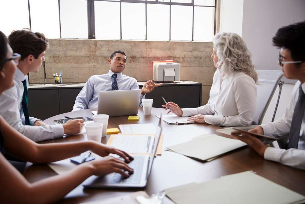 Business professionals discussing SM&CR compliance strategies - Global Banking & Finance Review