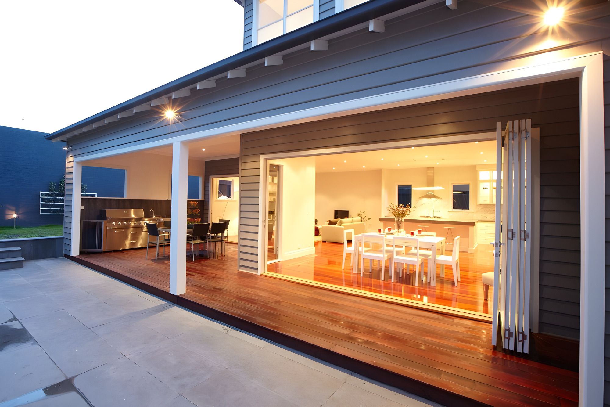Rear of the Carnegie custom home opened to the alfresco at dusk