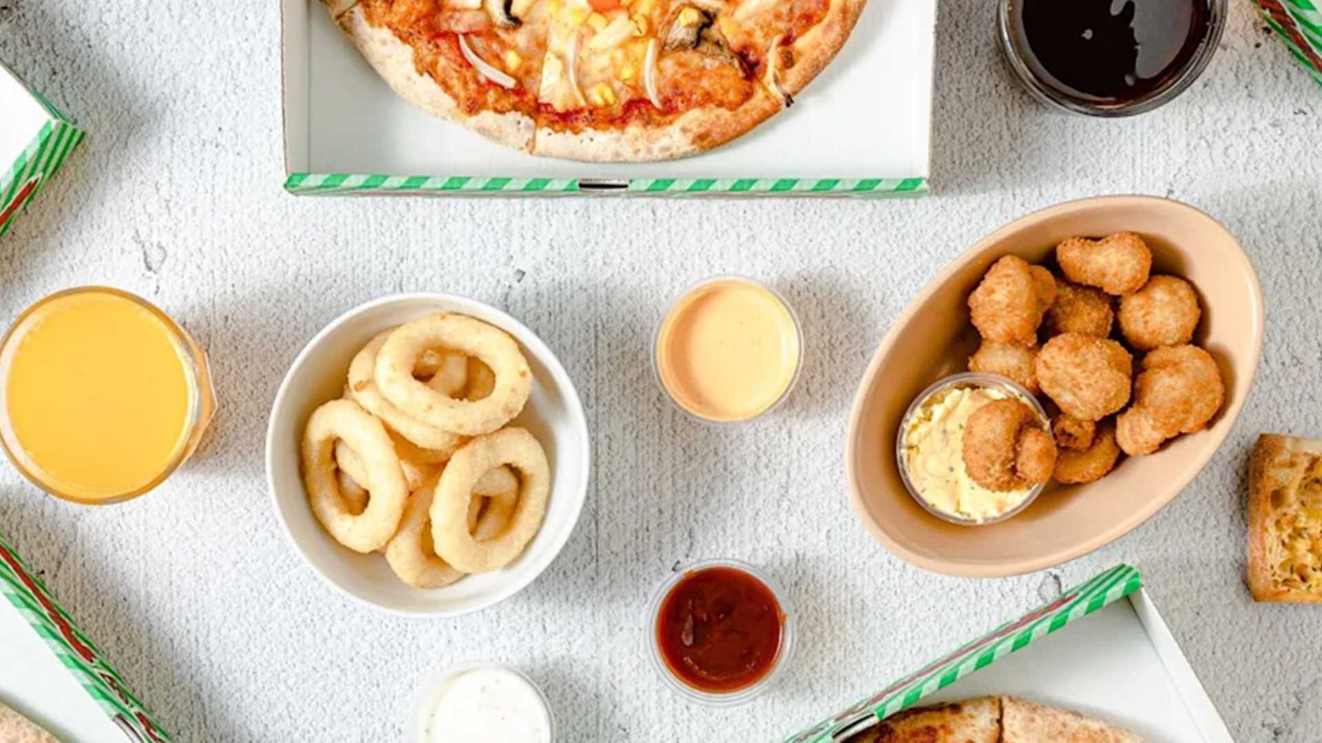 A spread of Mizzoni's pizza, onion rings, mushrooms and dips