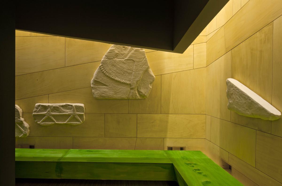 Phù điêu đá marble trắng trưng bày trên nền tường vàng