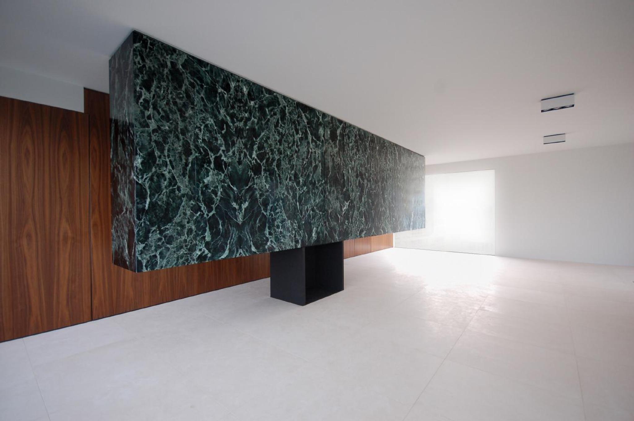 Vách ốp đá marble đen vân xanh với khối hộp mở trong gallery