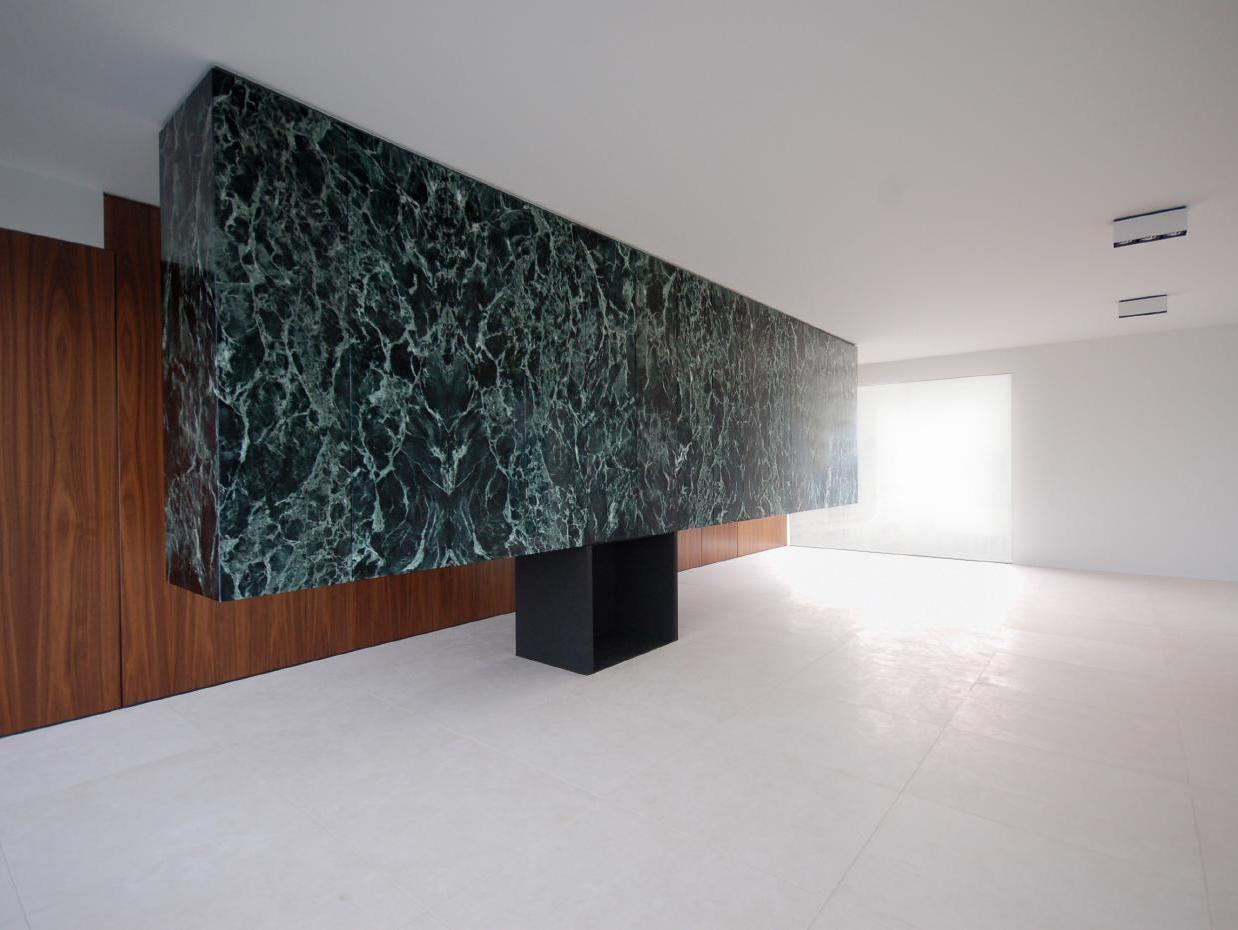 Vách ốp đá marble đen vân xanh với khối hộp mở trong gallery
