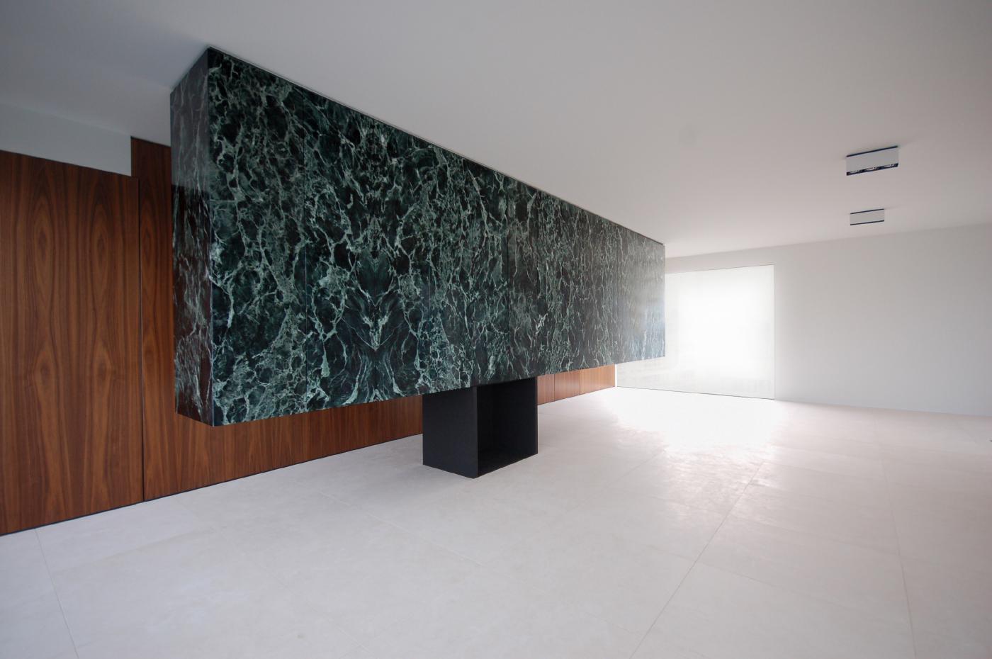 Vách ốp đá marble đen vân xanh với khối hộp mở trong gallery