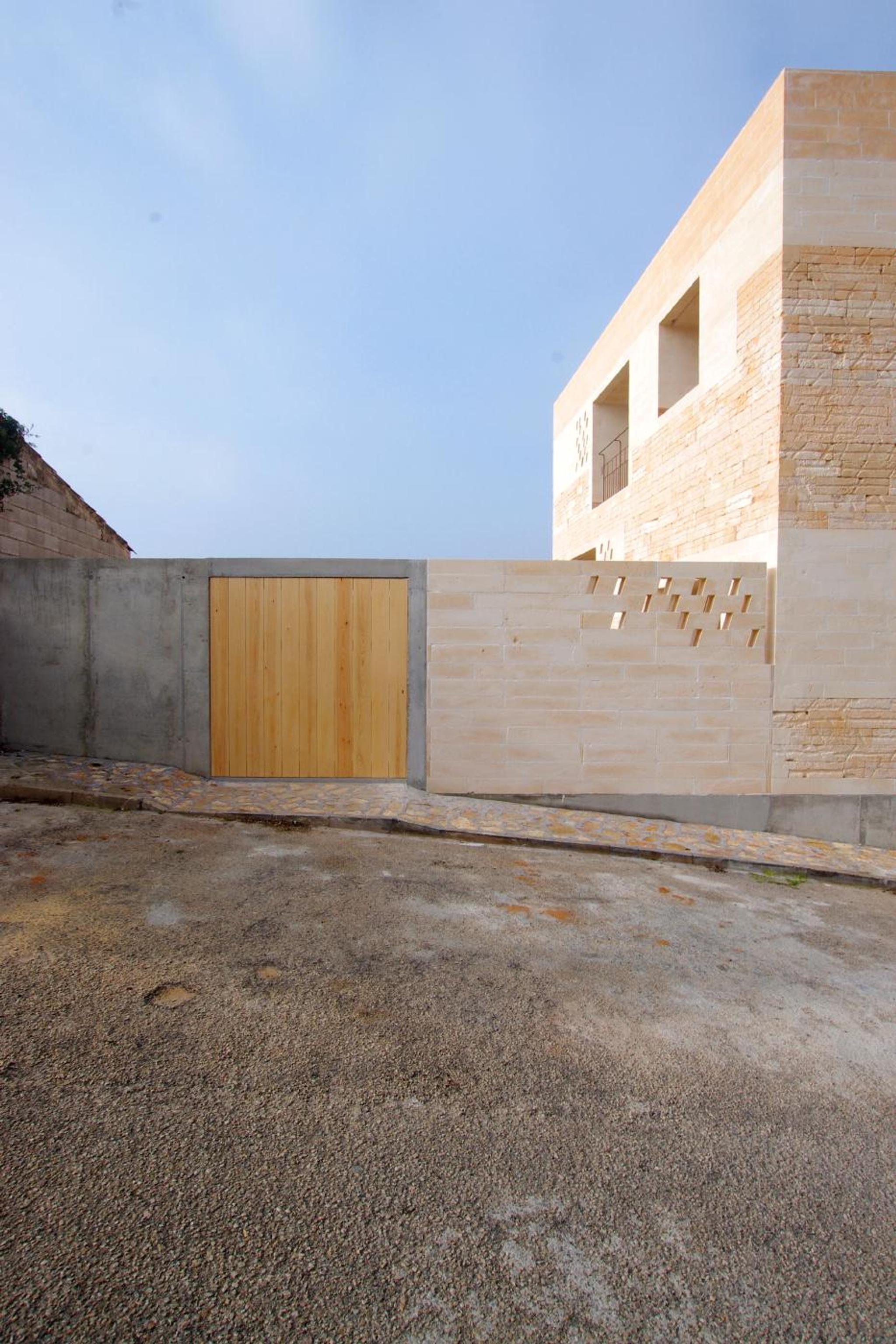 Sân trong rộng ốp đá travertine vàng be liền khối tường sàn