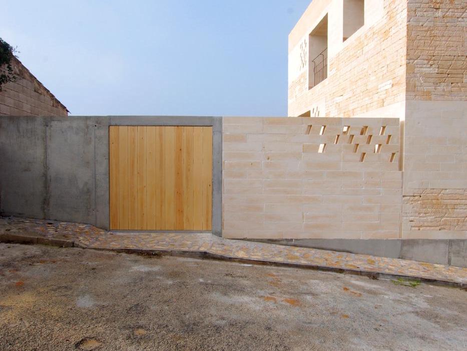 Sân trong rộng ốp đá travertine vàng be liền khối tường sàn
