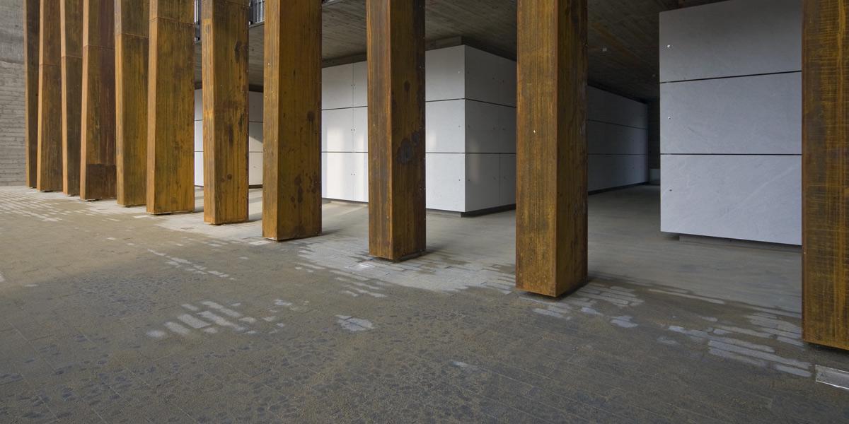 Hàng cột lớn ốp đá travertine vàng trong không gian sảnh hiện đại