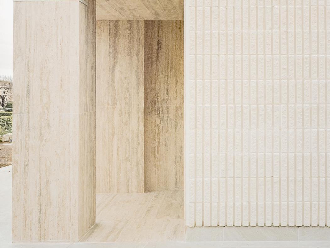 Mặt tường ốp tấm đá travertine kem chia ô đều kiến trúc hiện đại