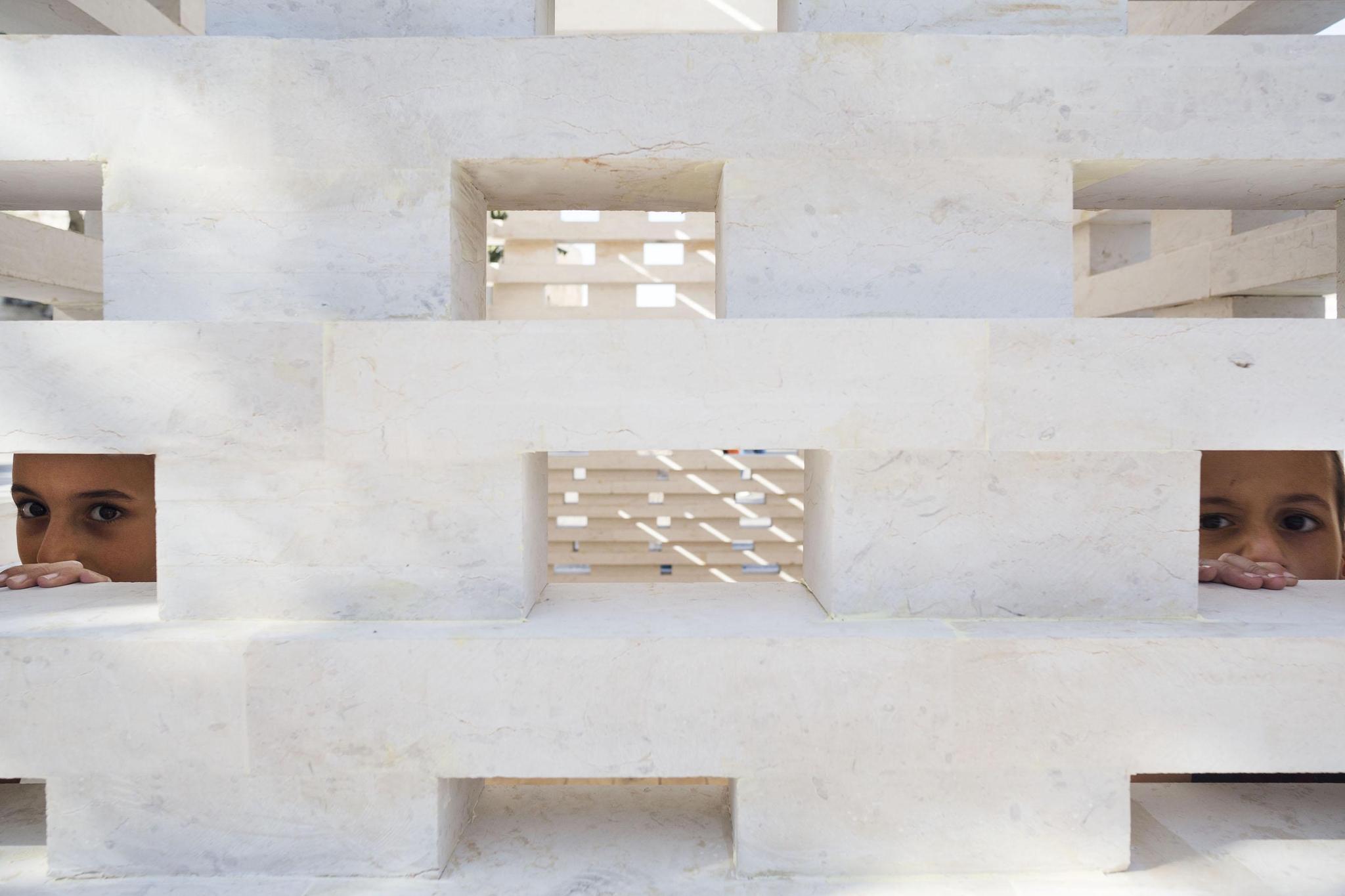 Cận cảnh tường ốp đá travertine vàng kem vân ngang khắc chữ