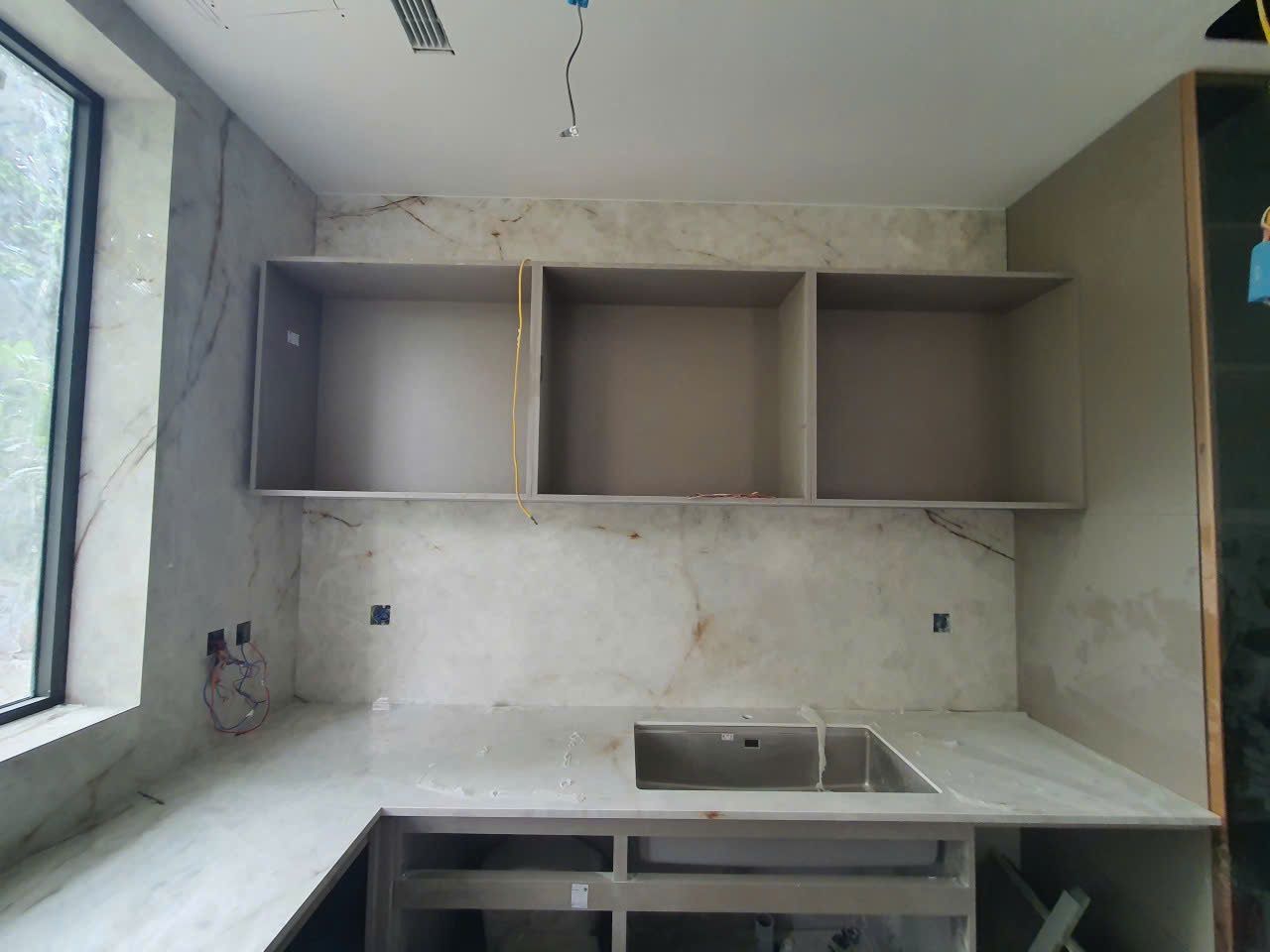 Mặt bếp + ốp tường bếp — Marble/quartzite trắng vân nâu