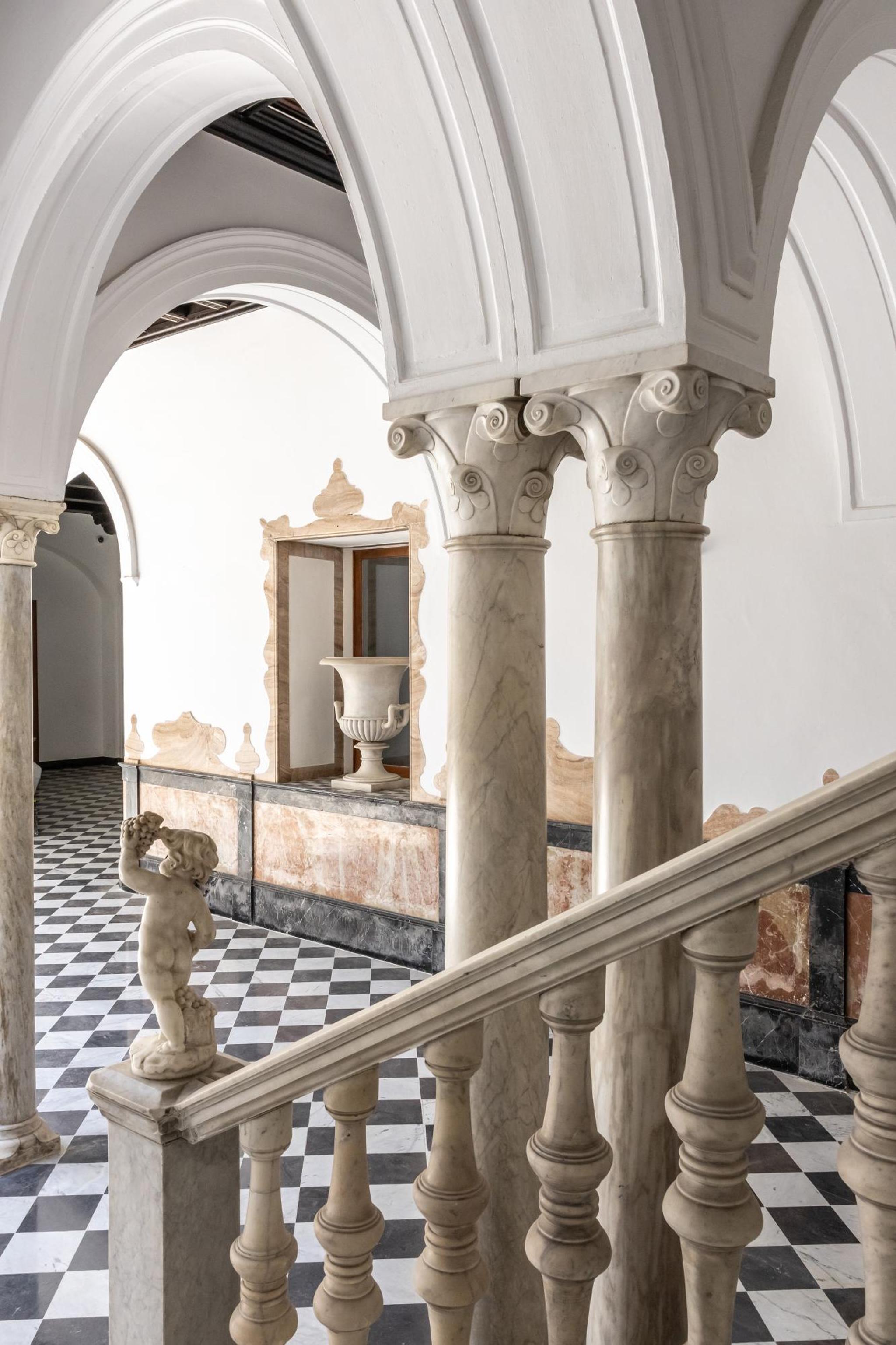 Cầu thang và lan can đá marble trắng cổ điển dưới hàng cột đá