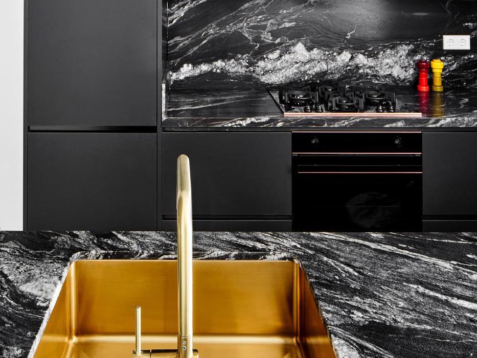 Phòng tắm lavabo đá marble đen vân trắng với chậu vàng đồng