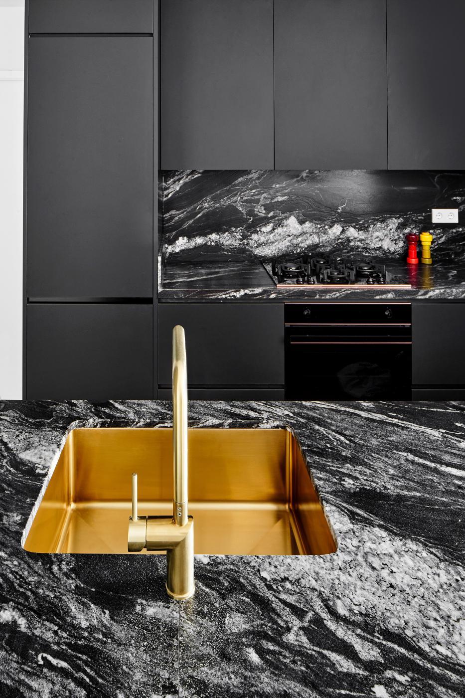 Phòng tắm lavabo đá marble đen vân trắng với chậu vàng đồng