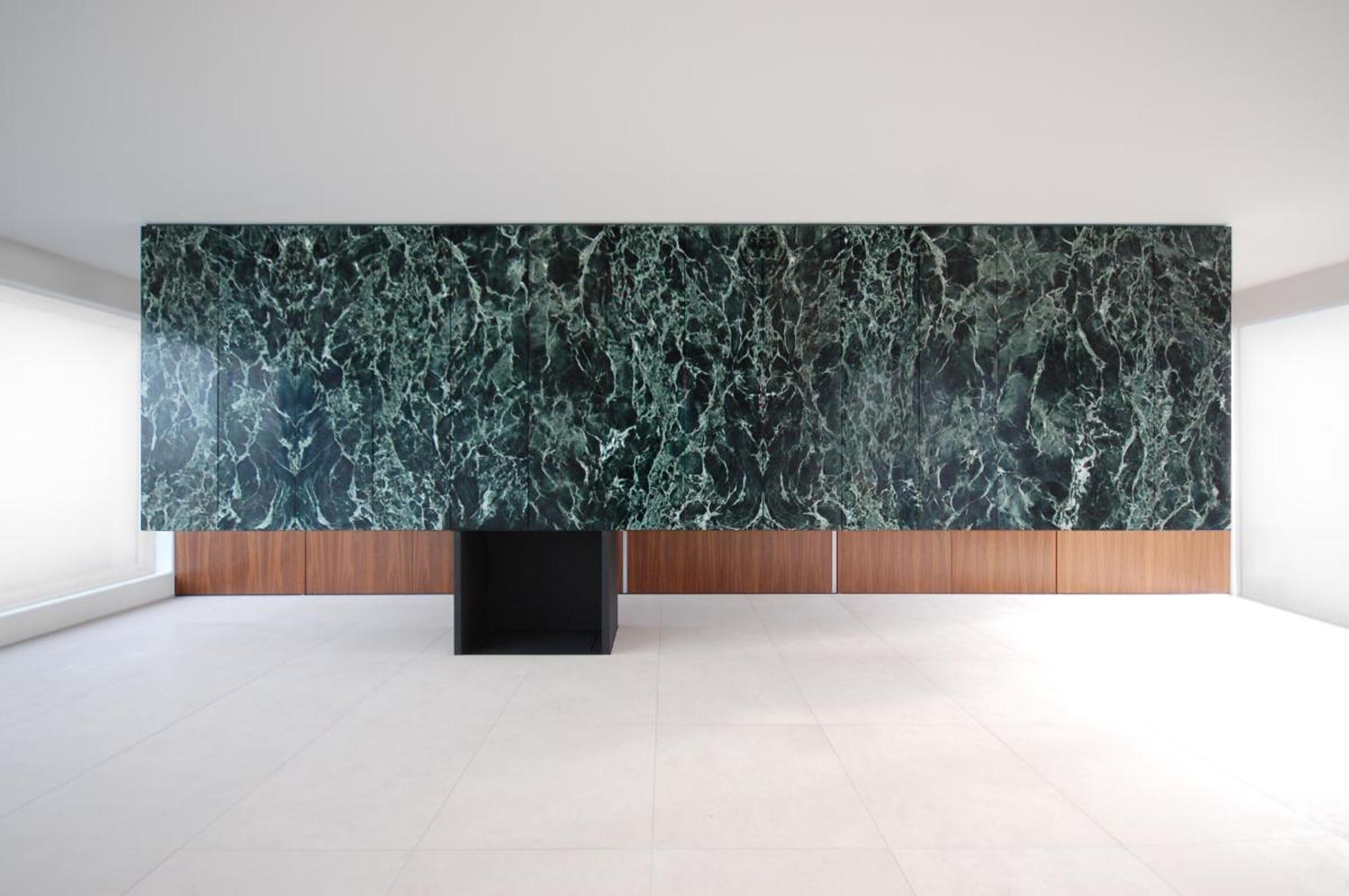 Khối tường ốp đá marble đen vân xanh đặt trong không gian trắng