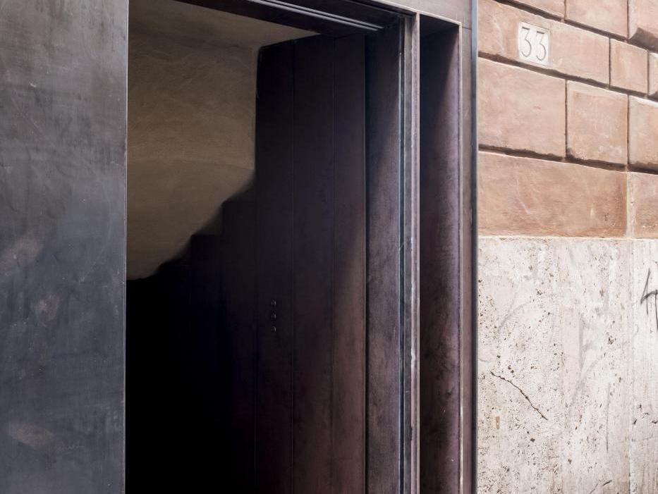 Tường ốp tấm đá granite nâu đỏ lốm đốm cạnh khung cửa tối