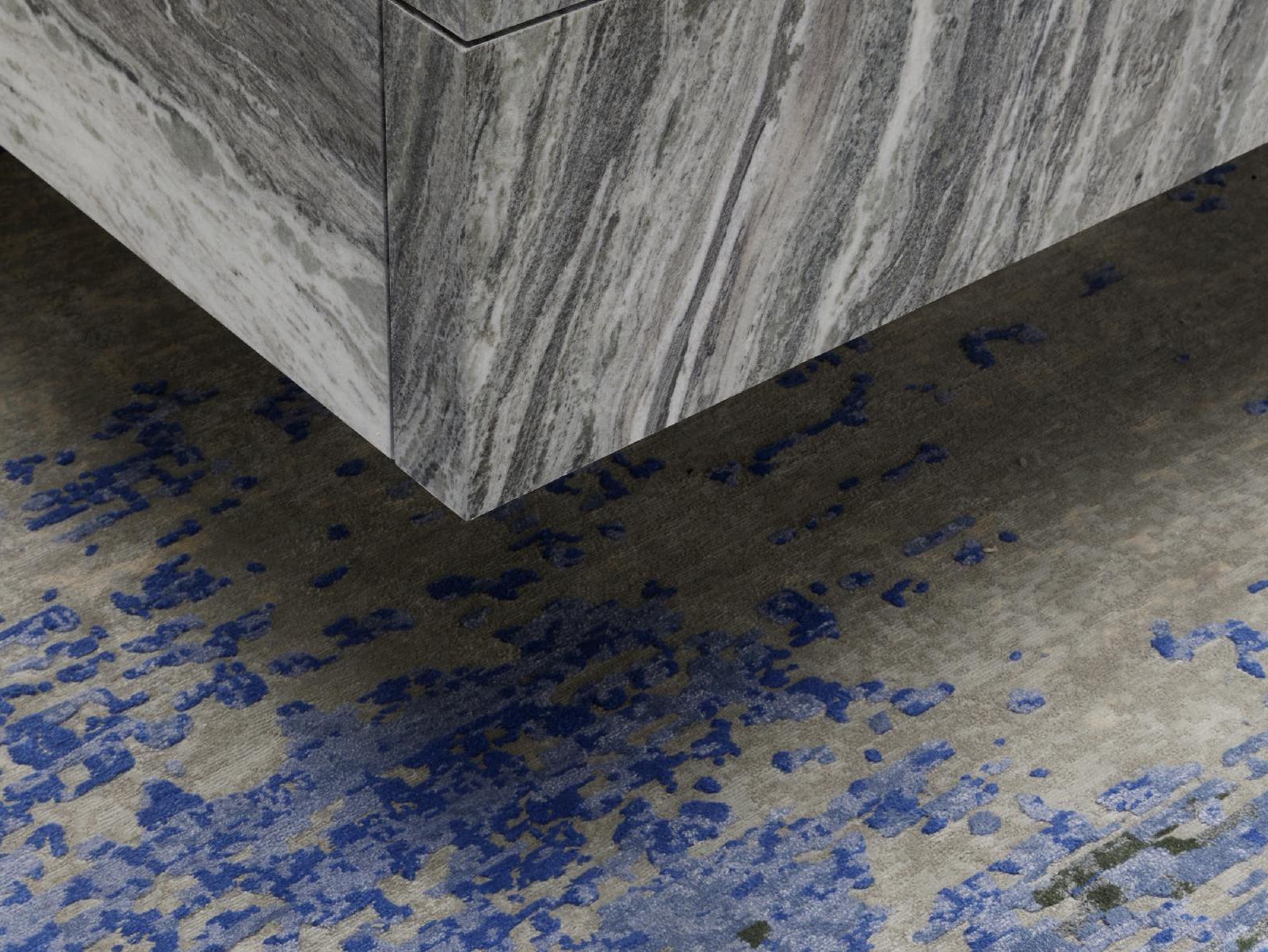 Khối đá marble trắng vân xám đặt trên nền sàn lốm đốm xanh