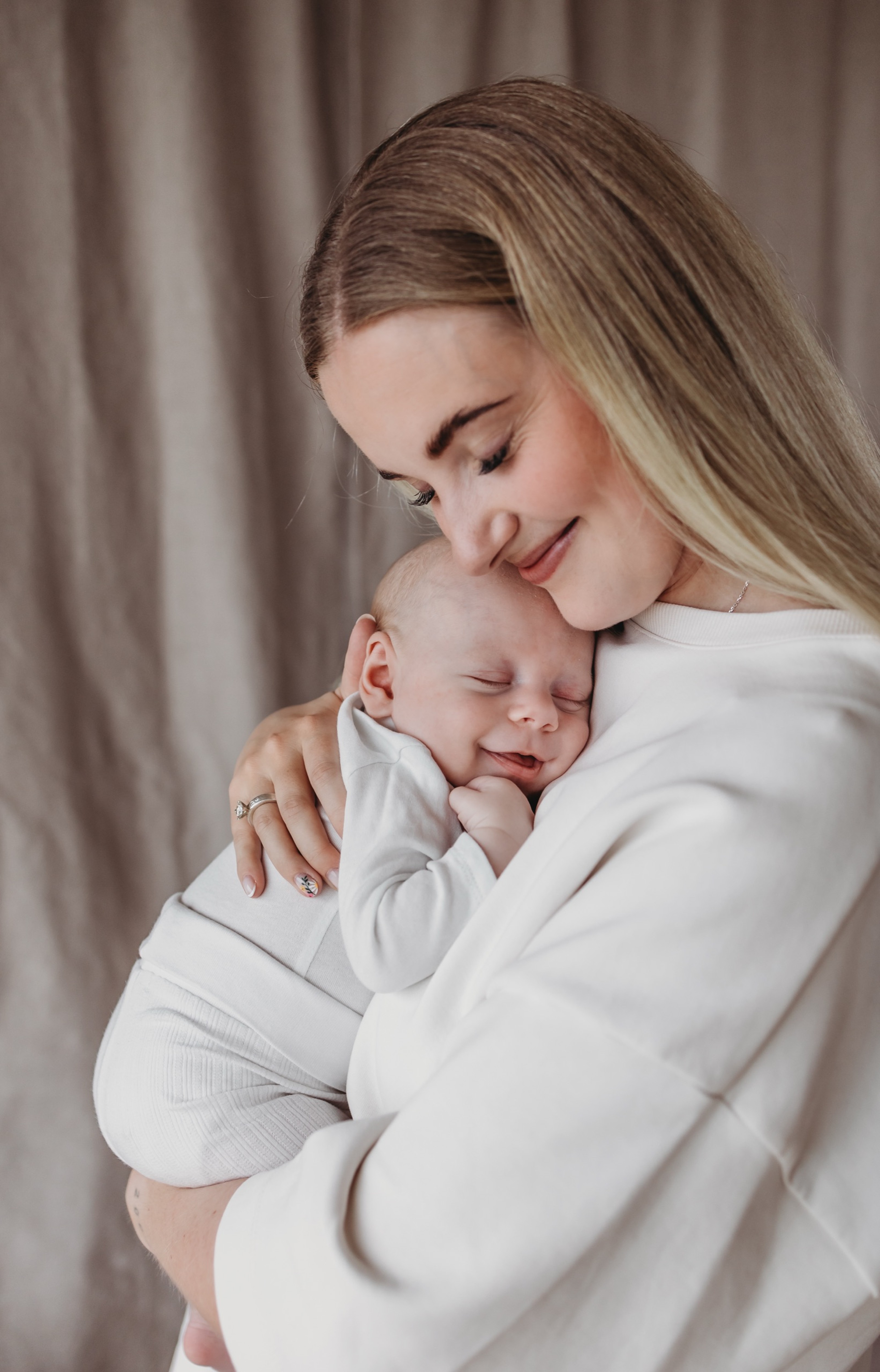 Nybagt mor holder sin sovende baby tæt