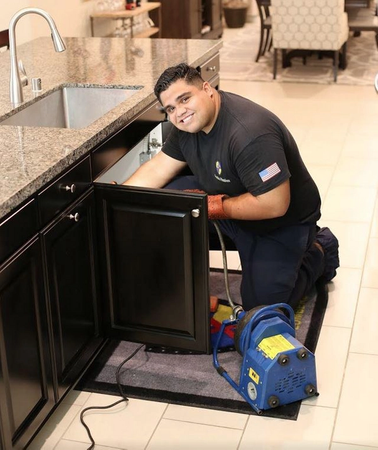 One of our senior plumbers performing drain cleaning services next to the client in Temecula, CA