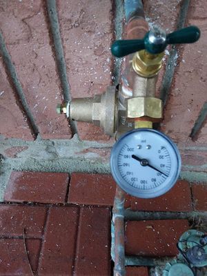 Pressure regulator sitting next to water valve outside of Tacome, WA, home.