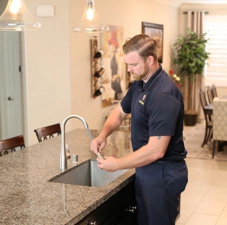 One of our skilled plumbers performing a kitchen faucet replacement for a client in Temecula, CA