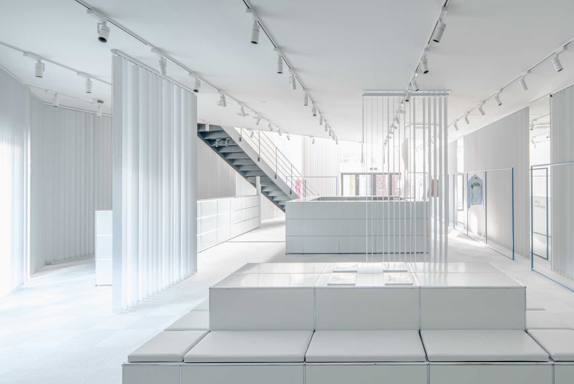 a white room with a staircase and white curtains