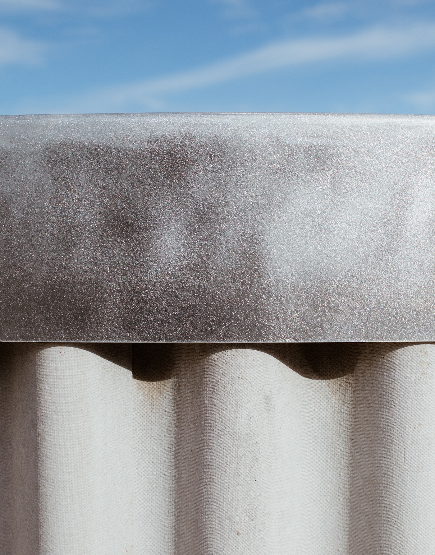a close up of a white wall with a blue sky in the background .