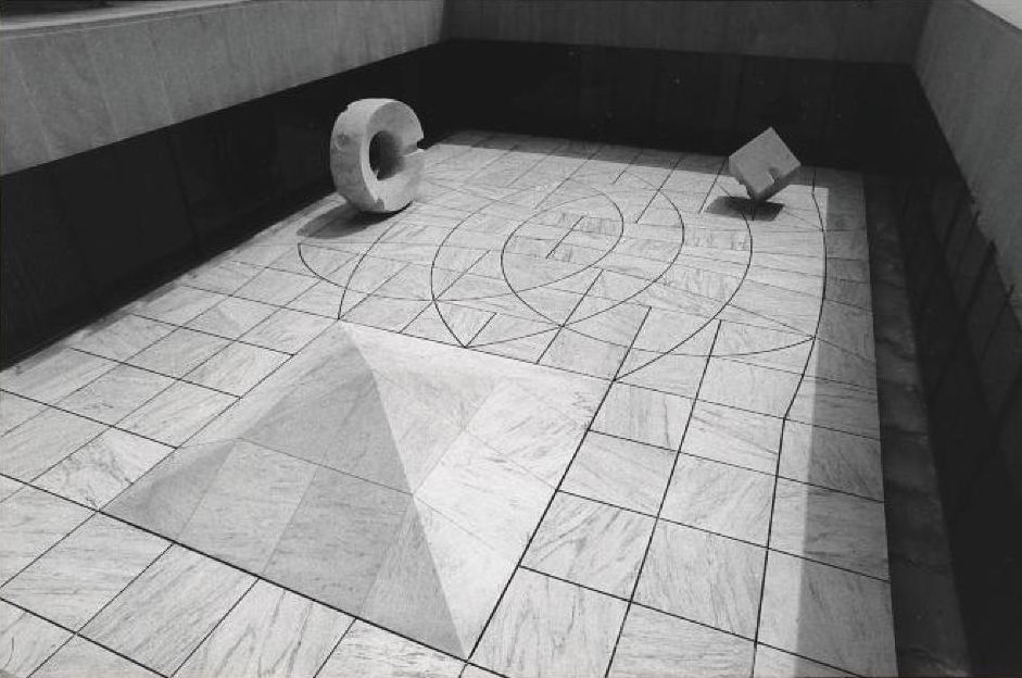 Black and white geometric art installation featuring a pyramid in a tiled floor, a standing ring, and a balanced cube. By Isamu Noguchi. Sunken Garden for Beinecke Rare Book and Manuscript Library