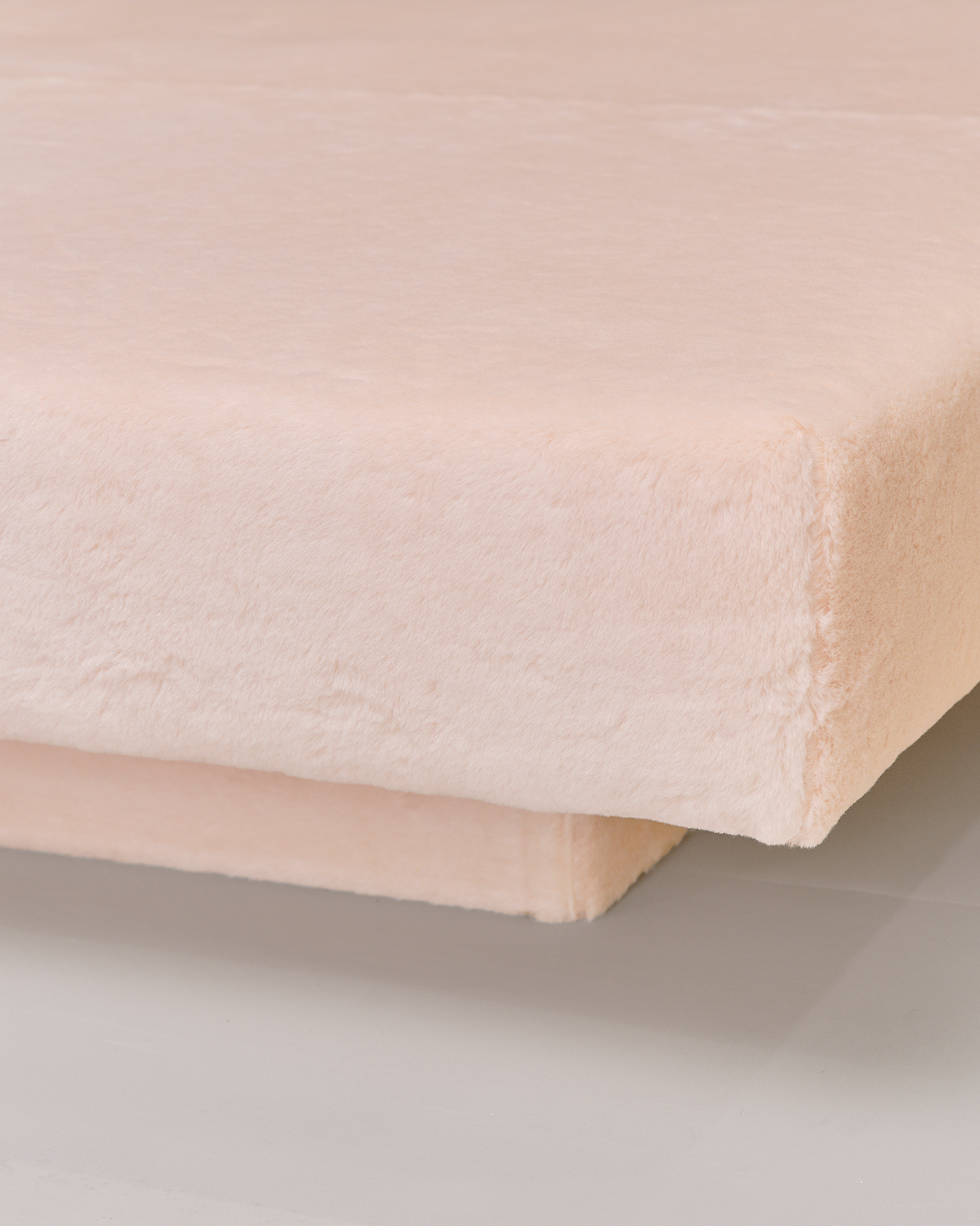 Blush pink plush fabric day bed.