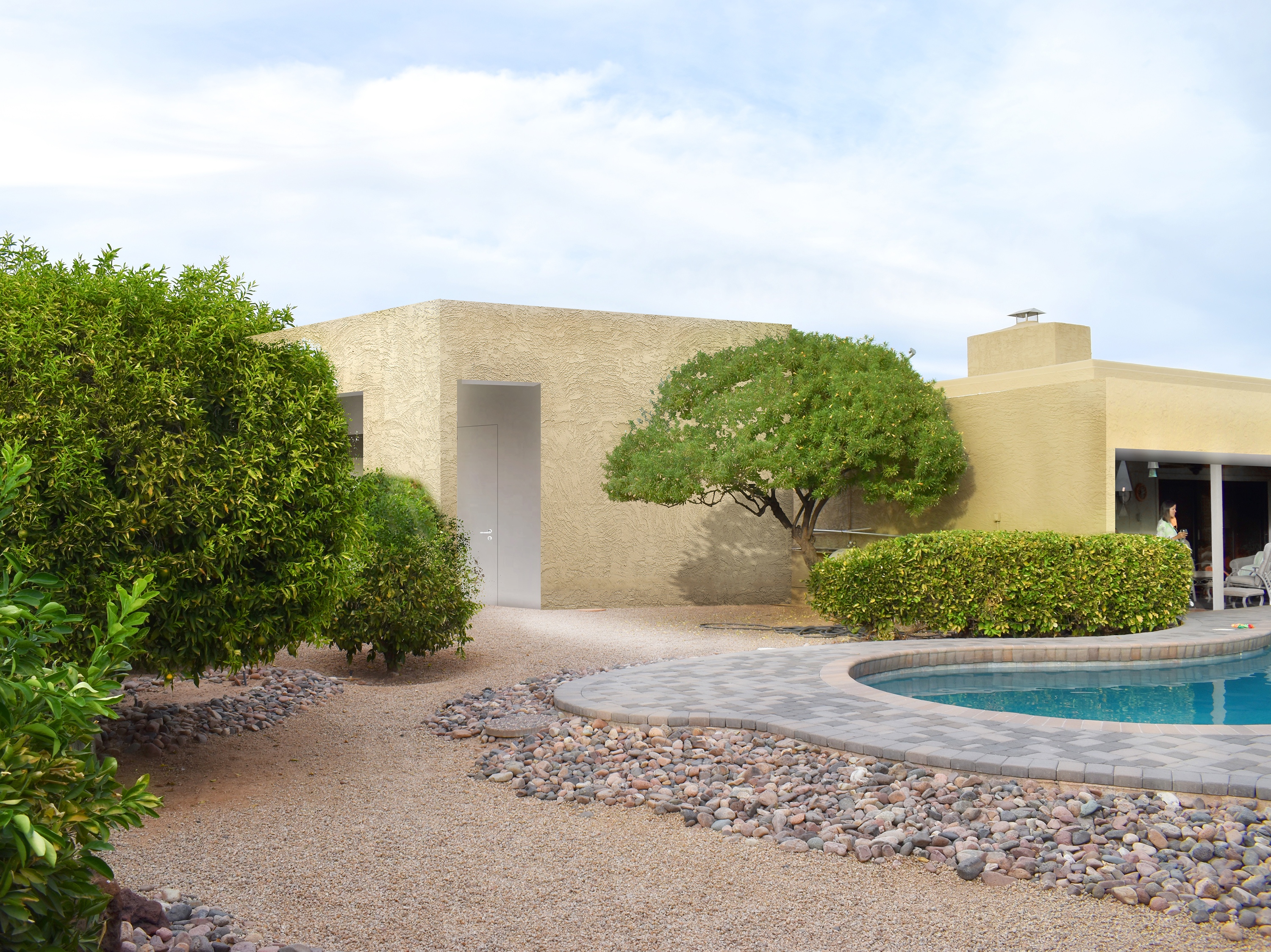 a house with a pool and trees in front of it