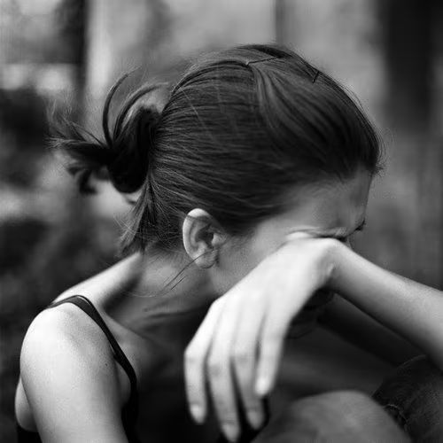 Woman covering her eyes with her hand in grief