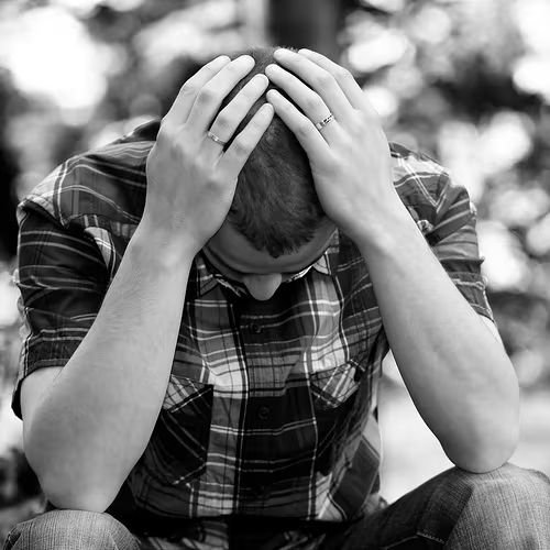 Man sitting with his head in his hands