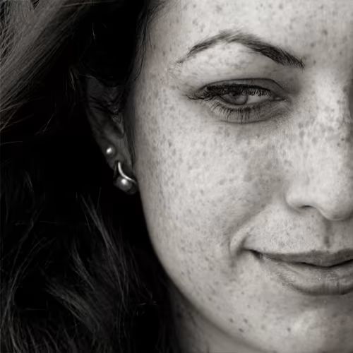 Close-up of a woman with freckles, smiling softly