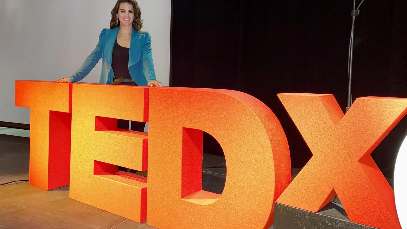 Renée Marino speaking on a TEDx stage