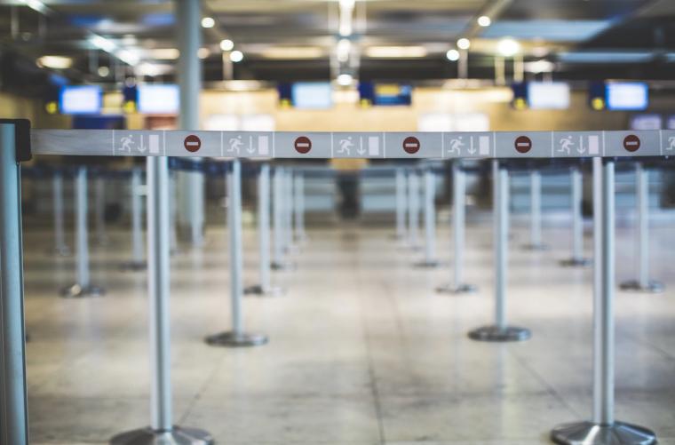 Empty airport immigration queue with directional signs, illustrating the I-94 arrival process explained by Immiva