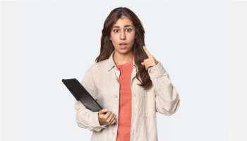 How to Check EAD Status: Quick and Easy Steps | Immiva Surprised woman holding a tablet, pointing upwards as if she just realized something important, illustrating the process of checking EAD status.