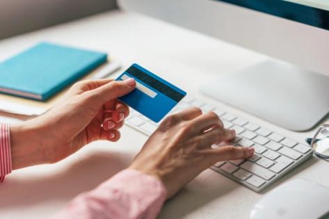 How to pay USCIS filing fee | Immiva Person entering credit card details on a laptop to pay USCIS filing fees online, illustrating how to pay immigration application fees by card or ACH