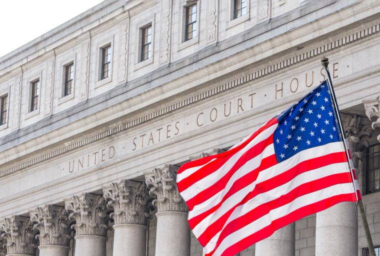 American Flag at United States Courthouse for N-400 Citizenship | Immiva US flag waving in front of the United States Court House in New York, representing N-400 citizenship considerations for applicants with a criminal record