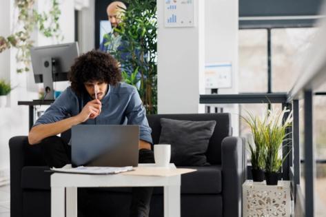 Young professional working on a laptop in a modern US coworking space after receiving J-2 work authorization