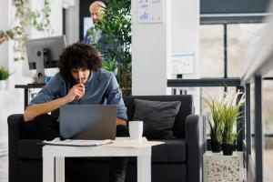Young professional working on a laptop in a modern US coworking space after receiving J-2 work authorization