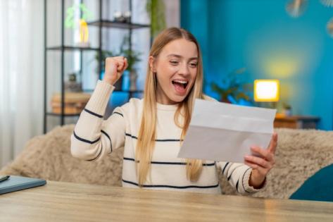 Excited H-1B Applicant Receives Selection Notice – FY 2026 Visa Lottery | Immiva Young woman celebrating after receiving a letter, symbolizing successful H-1B visa selection for FY 2026