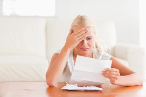 Avoiding Common H-4 EAD Application Mistakes | Immiva Worried woman holding her head while reading a letter, illustrating stress caused by H-4 EAD application mistakes – Immiva immigration assistance