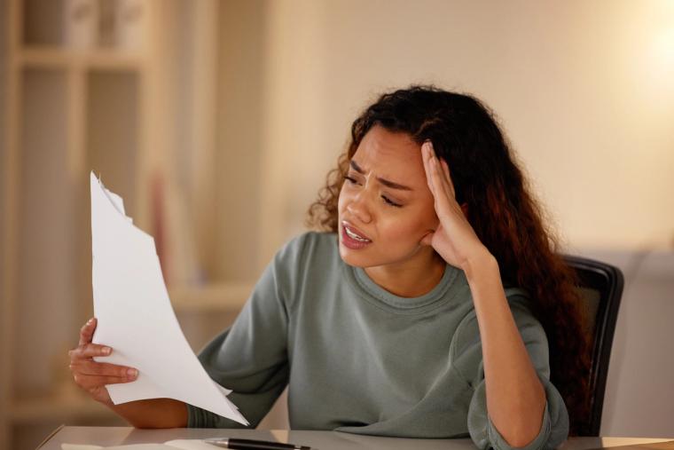 N400 Citizenship Application Mistakes Stress | Immiva Woman stressed while reviewing N-400 citizenship application paperwork - Immiva helps avoid common naturalization form mistakes