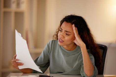 Woman stressed while reviewing N-400 citizenship application paperwork - Immiva helps avoid common naturalization form mistakes
