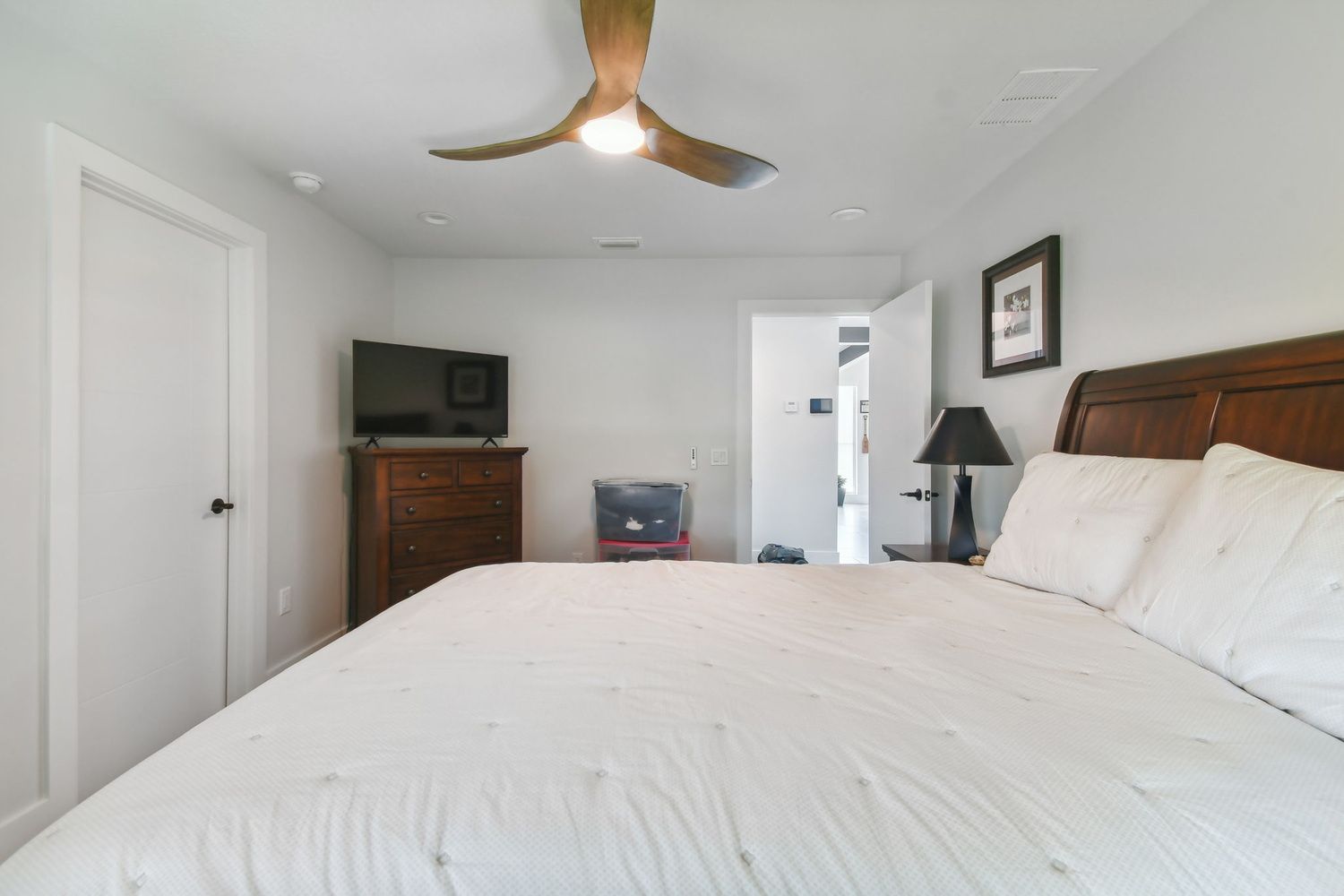 Minimalist bedroom remodel with dark wood furniture and modern fan — Waterfront home renovation, Bradenton, FL
